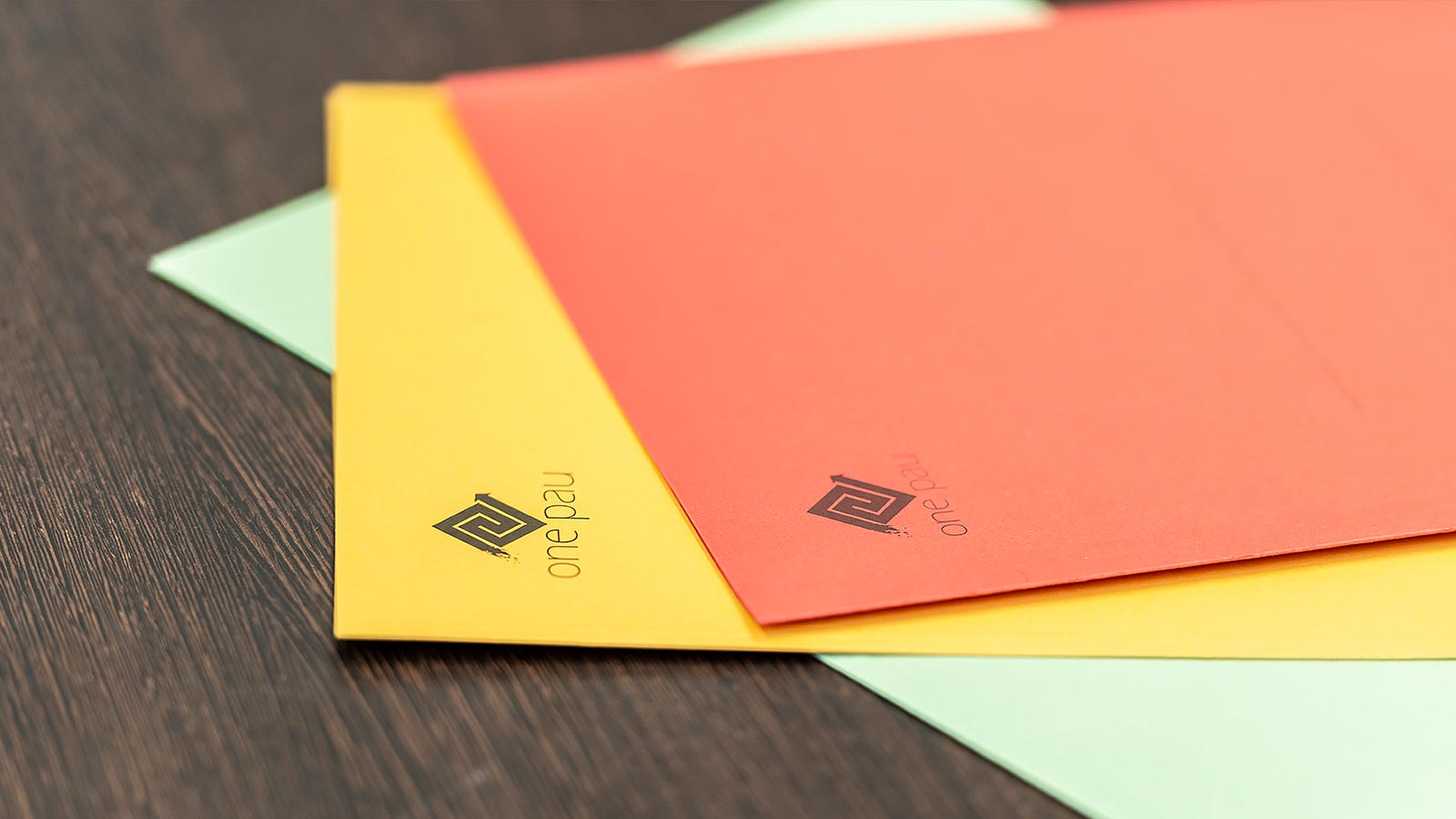 Some colored folders with the logo of Studio Onepau in Bolzano